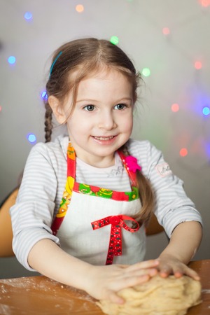 Cute girl making dough for Christmas traditional cookiesの写真素材