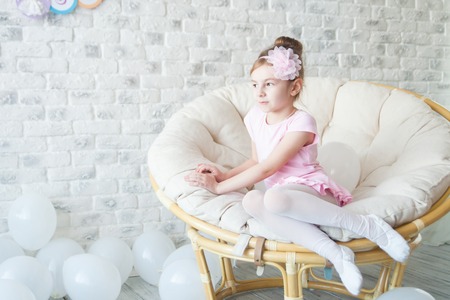 Little ballerina in a studio with white balloons.の写真素材
