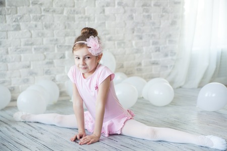 Little ballerina in a studio with white balloons.の写真素材