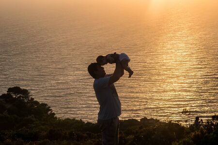 Happy father with a small daughter on sunset. Zakynthos, Greece