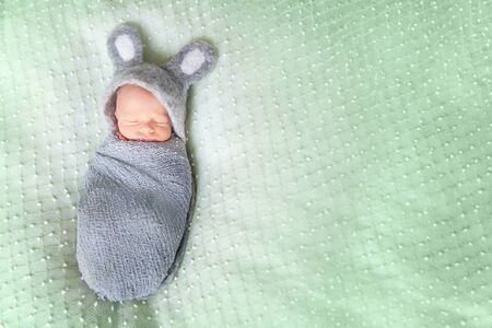 Cute sleeping newborn baby dressed like Easter bunnyの写真素材