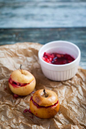Red baked apples with nuts and raspberryの写真素材