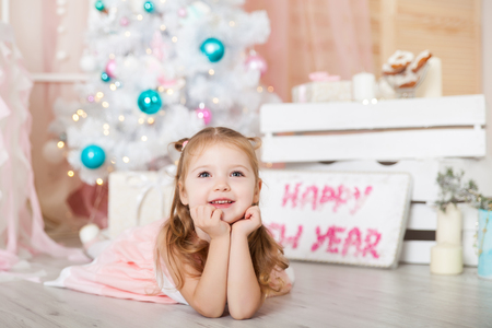 Cute girl in a Christmas decorated studio in pastel colorsの写真素材