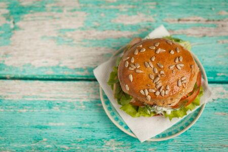Fresh homemade burger with chicken, grilled pineapple and garlic sauce on on a green backgroundの写真素材