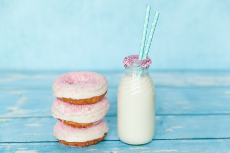 Tasty donuts with pink sprinkles with milk bottleの写真素材