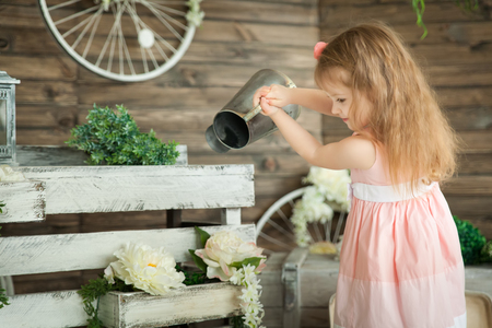 Portrait of a small girl in a spring studio. Rustic decorの写真素材