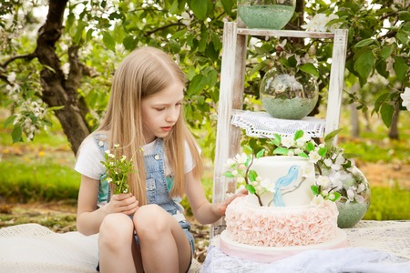 Beautiful young girl in spring decorations in an apple tree blossom garden
