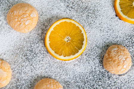 Homemade orange crinkle cookies with powdered sugar icing. Cracked citrus biscuits on wooden backgroundの写真素材