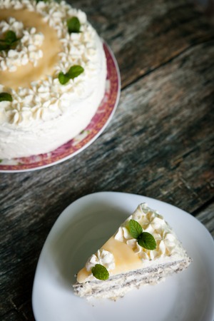 Delicious homemade poppy seed cake with lemon curd and whipped cream on woooden rustic backgroundの写真素材