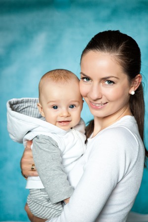 Young beautiful mother with baby boy. Mother hugging and having fun with her blue-eyed son