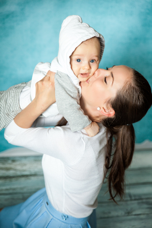 Young beautiful mother with baby boy. Mother hugging and having fun with her blue-eyed sonの写真素材