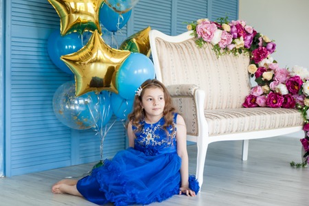 Birthday party in blue and gold collors. Studio session. Fashion girl celebrating her birthdayの写真素材