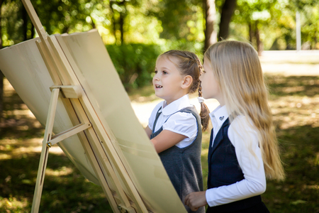 Little school girls in a uniform with a world map. Back to school outdoorsの写真素材