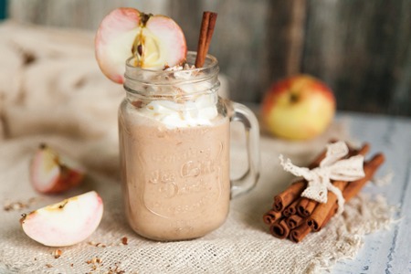 Healthy smoothie Apple Pie with nuts, whipped cream and autumn spices in mason jars. Seasonal autumn drinkの写真素材