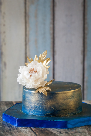 Blue and gold wedding cake with a big sugar flower. 2 Tier blue elegant birthday cakeの写真素材