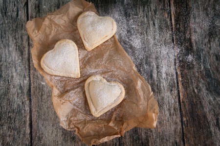 Homemade heart shape cookies with vanilla custard cream on wooden background. Valentive's Day conceptの写真素材