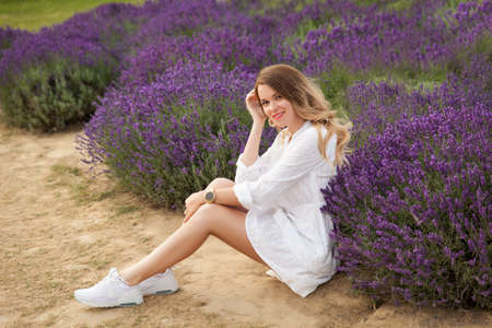 Young woman in a white dress having fun in a lavender fieldの写真素材