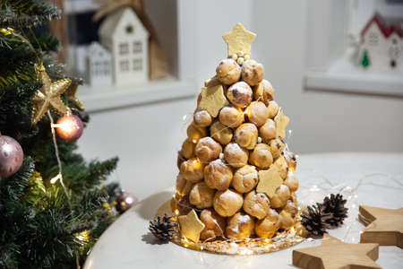 Croquembouche profiteroles cake with caramel and vanilla custard cream for Christmas with New Year tree on backgroundの写真素材