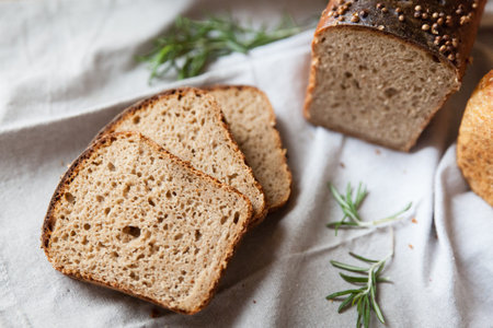 A loaf of bread on a linen fabric. Defocused lights of Christmas tree. Holiday mood. Christmas and...