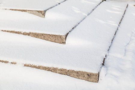Stone stairs covered with snow after snowfall in winter.の写真素材