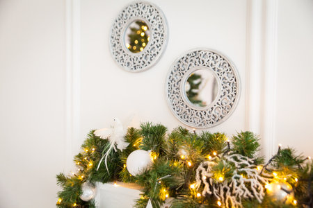 Christmas composition with two mirrors near light wall and decorated fir branchの写真素材