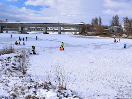 Children play on a frozen lake in the city park.の写真素材