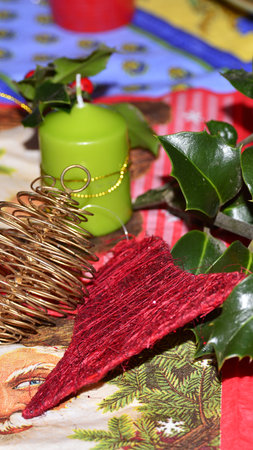 Christmas decoration with holly leaves, candles and golden ornamentsの写真素材