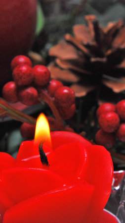 Candle and christmas decorations, closeup of red candle burningの写真素材