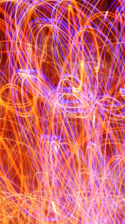 Abstract light background. Party illustration. Long exposure of firework with motion blur.の写真素材