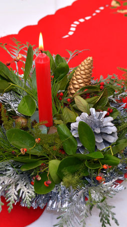 Christmas decoration with red candle and mistletoe on a red background.の写真素材