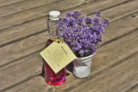 Homemade Lavender Syrup in a bottle with a bouquet of Common Lavender (Lavandula angustifolia). Recipe in German attached to the bottle.の写真素材
