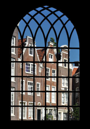 Amsterdam, Netherlands - July 24, 2012: Houses of Begijnhof trough the window of the Begijnkapel (chapel).のeditorial素材