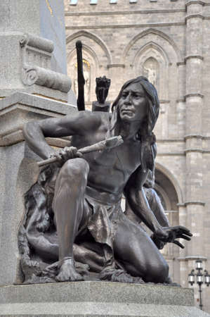 Montreal USA - July 16, 2013: Iroquois statue on Place d'Armes, Maisonneuve Monument in Montreal, Canadaのeditorial素材