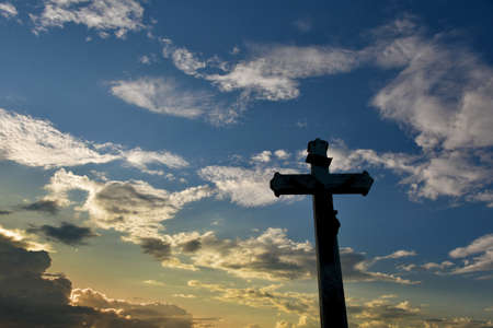 Christian wayside cross in front of cloudy sky in the evening after a thunderstormの写真素材