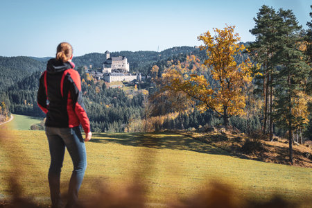 Female hiker in front of castle Rappottenstein in the warm light of autumnのeditorial素材