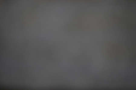 Abstract heavily blurred background in soft soothing dark black and gray tones. obtained by blurring the optics of the camera without the use of program editors.の写真素材