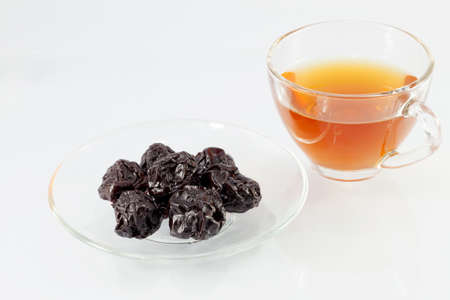 Dried plums - prunes in the bowl with teaの写真素材