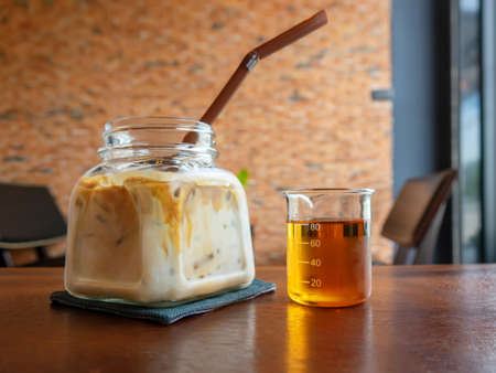 Milk is poured into coffee with ice and honey  glass of refreshing iced coffeeの写真素材