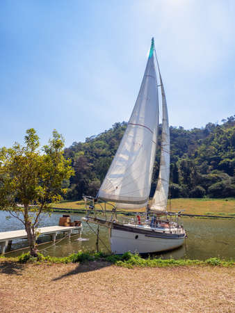 Sailing ship yacht with white sails in the lake