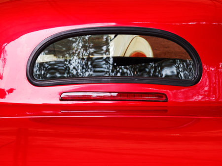 Rear window glass on red antique carの写真素材