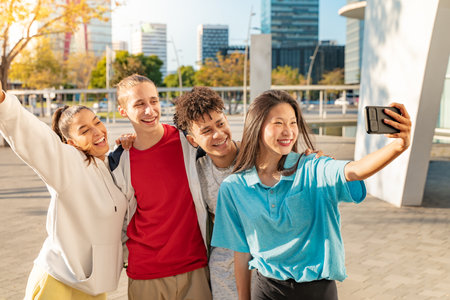 Cheerful young people taking group selfie on the city street. Multicultural friends.