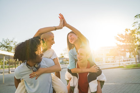 Friends riding on top of each other happily high five and celebrating joyfully with the sun back...