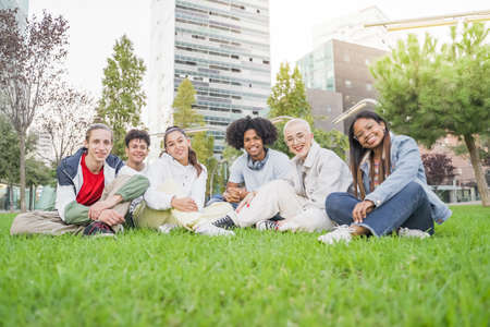 Group of multiethnic friends having fun together with self portrait on grass in the park. Friendly youth concept with happy young people students outside in the campusの写真素材