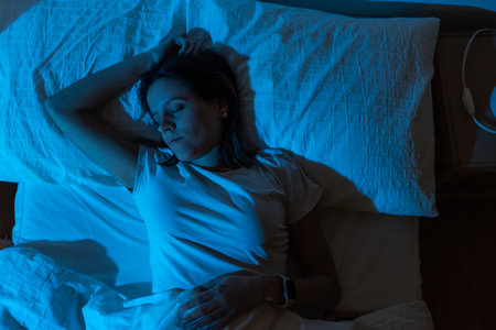 Top view of a beautiful girl sleeping in her bed with Blue Color from the moon. Sleep comfortably and peacefully concept.の写真素材