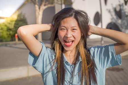 Portrait of a beautiful asian woman smiling and looking at camera outdoorsの写真素材