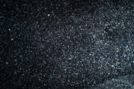 Abstract real dust particles on black background glittering sparkling bokeh overlay with copy space.