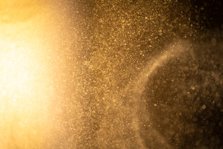 Gold dust particles abstract Bokeh star particle on Black Background. Futuristic dots in space.の写真素材