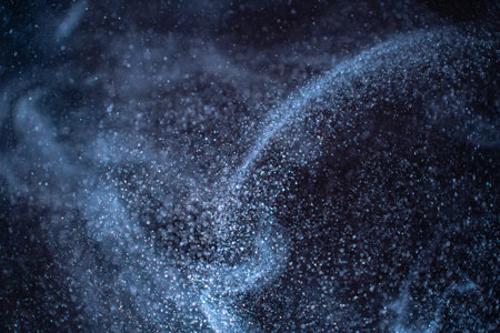 Dust particles cloud generating abstract shape on black background with copy space for text.の写真素材