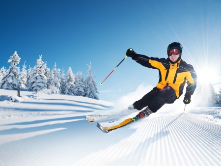 Skier in mountains, prepared piste and sunny dayの写真素材