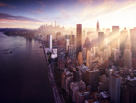 New York City - beautiful colorful sunset over manhattan fit sunbeams between buildingsの写真素材